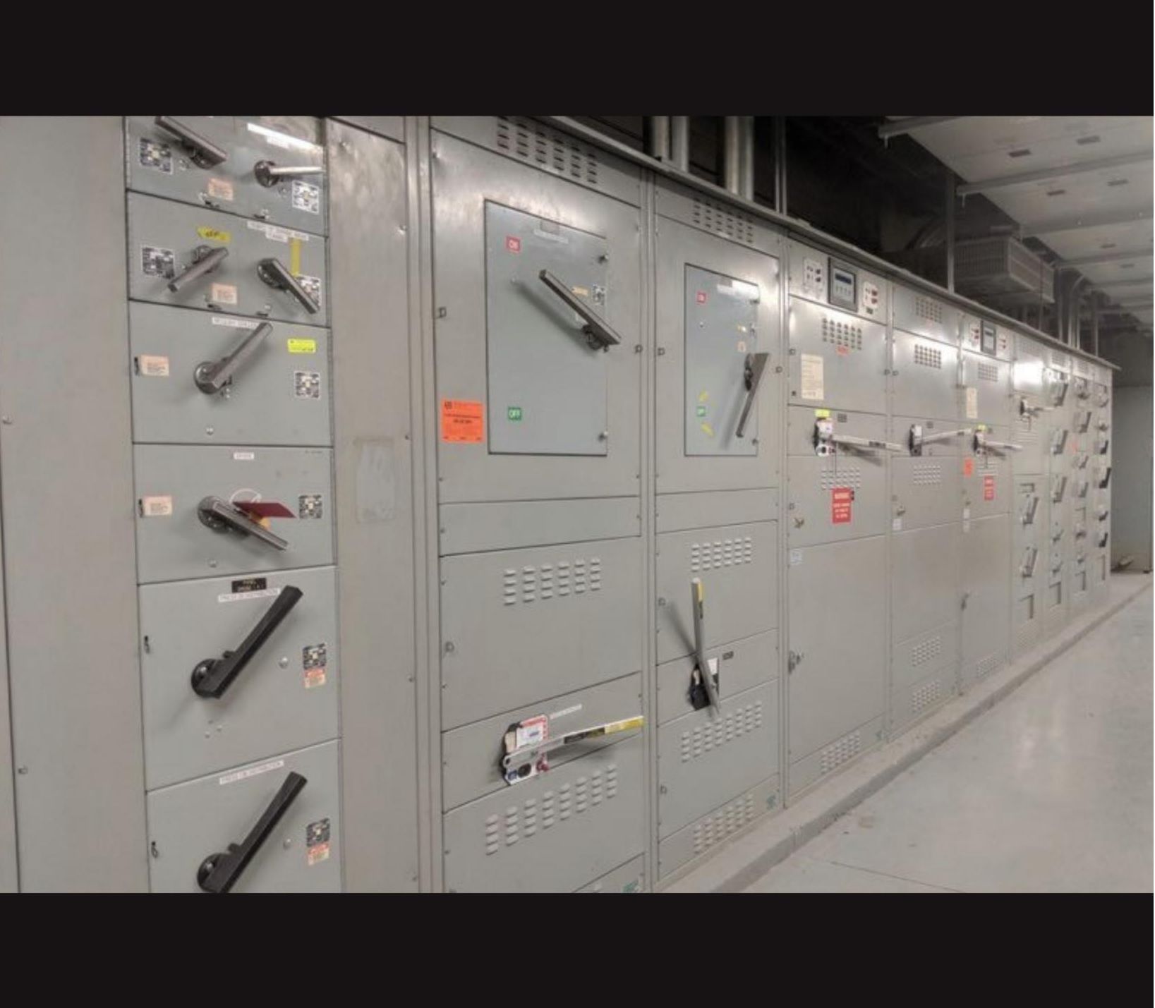 Industrial Electrical Contractor - A row of electrical panels with a lot of switches on them.