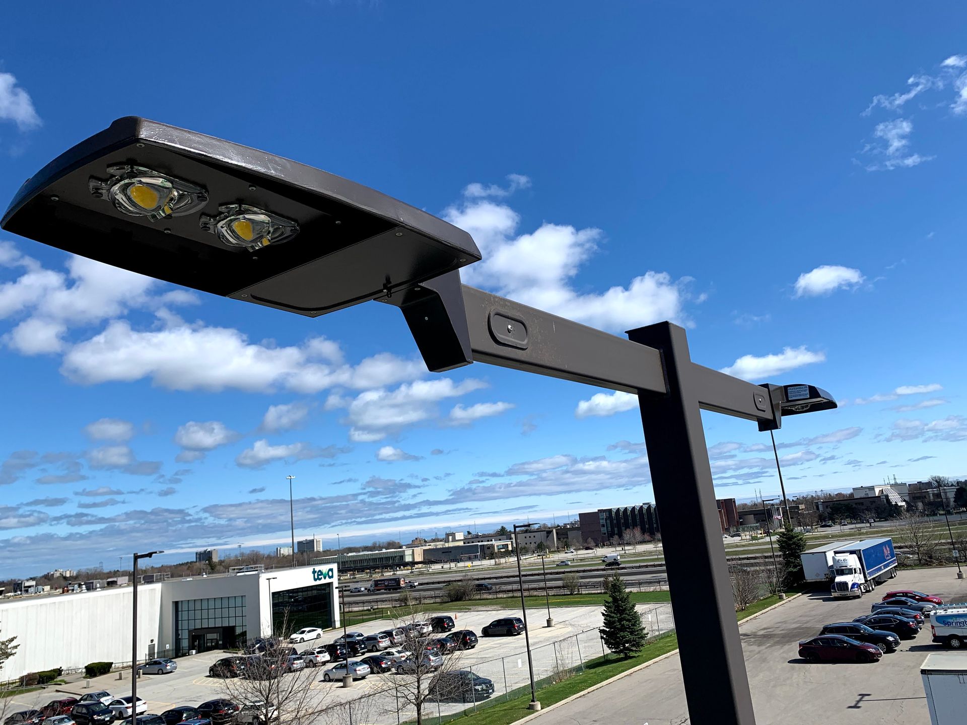 Commercial Electrical Contractor - A street light is sitting on top of a pole in front of a building.