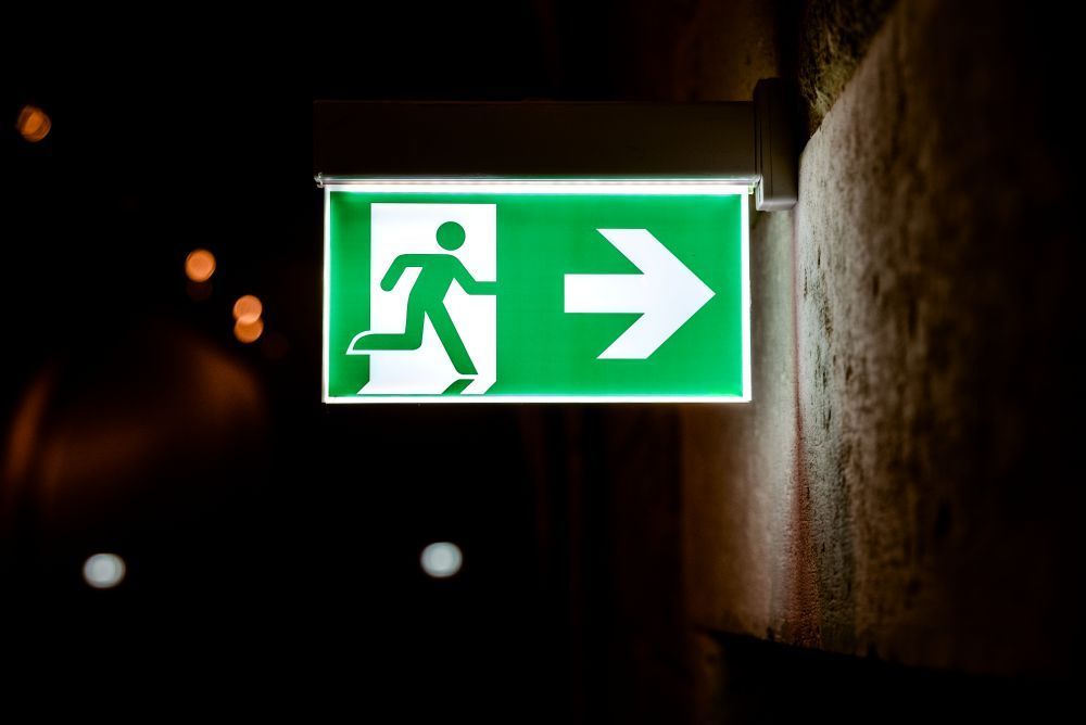 Commercial Electrical Contractor - A red exit sign is lit up in a dark room