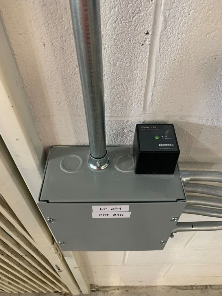 Residential Electrical Contractor - A box is hanging from the ceiling next to a brick wall.