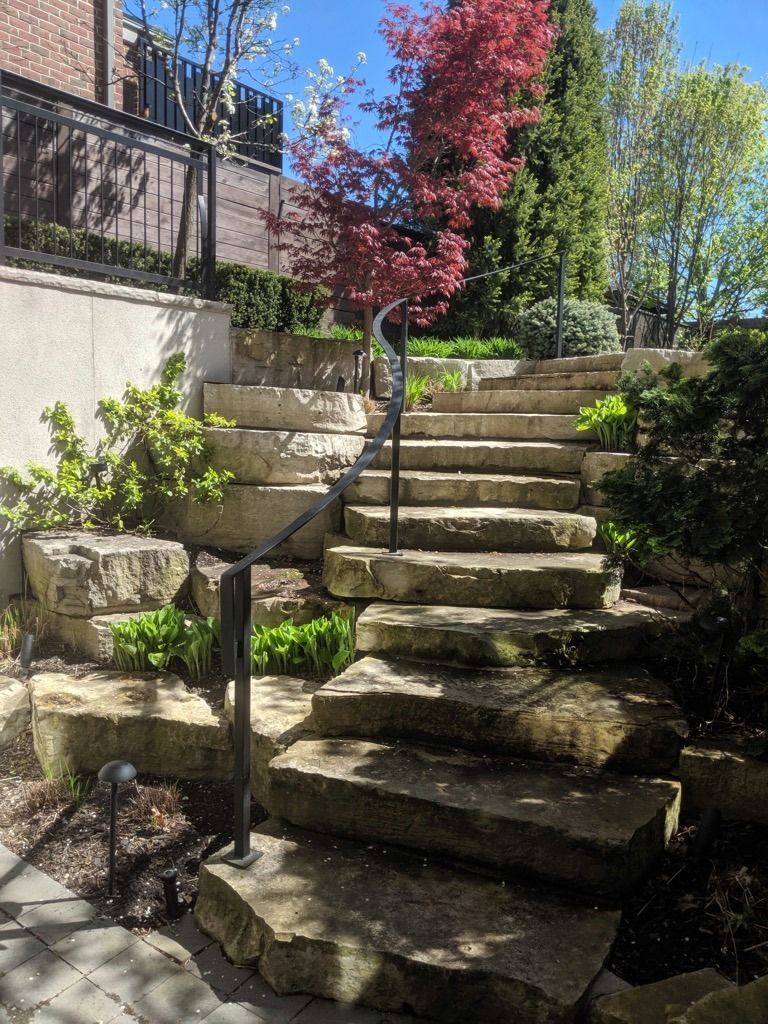 Residential Electrical Contractor - A set of stone stairs leading up to a house in a garden.