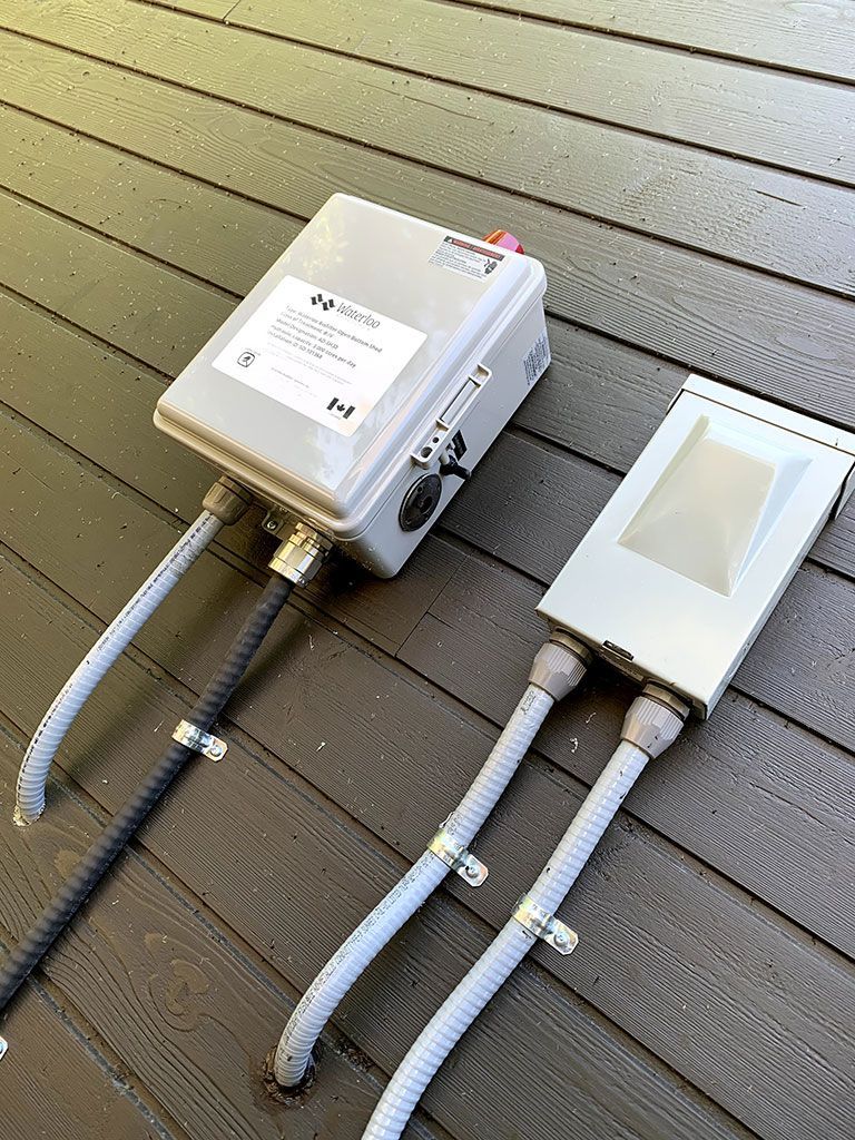 Residential Electrical Contractor - A couple of electrical boxes sitting on top of a wooden deck.