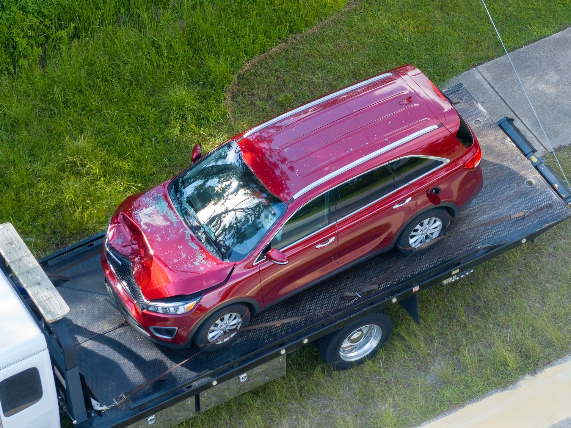 Red SUV on a tow truck; front end damaged.