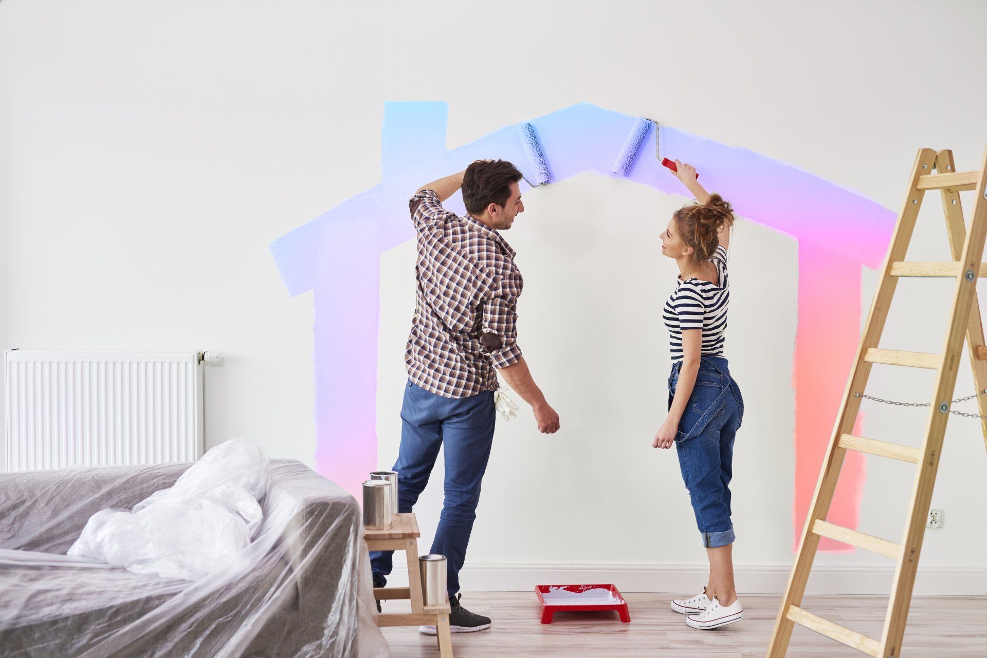 Couple painting house shape on wall