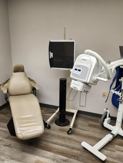 A dental office with a dental chair and a monitor.