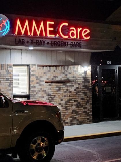 A truck is parked in front of a building that says mme care