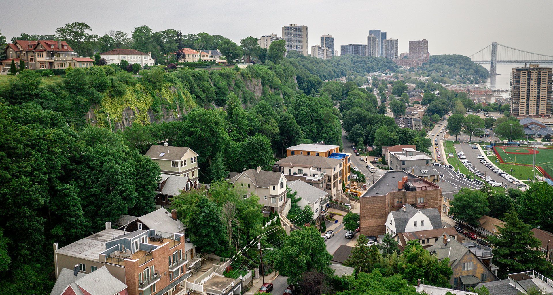 An aerial view of a residential area with a city in the background.