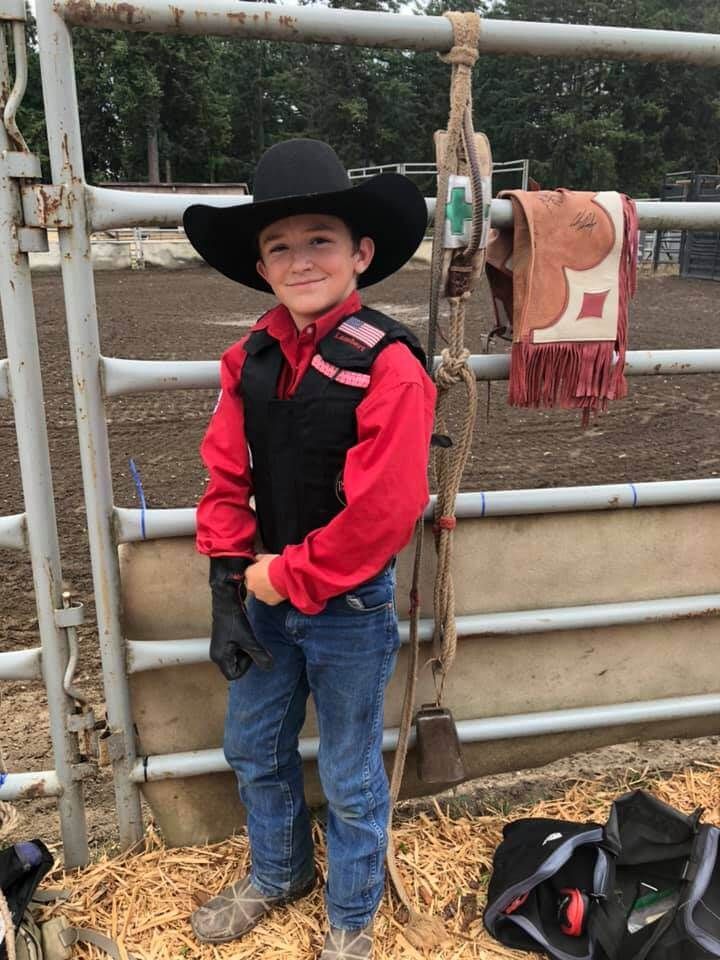 Young boy in cowboy attire, standing near rodeo equipment | Genesis Automotive and RV Repair