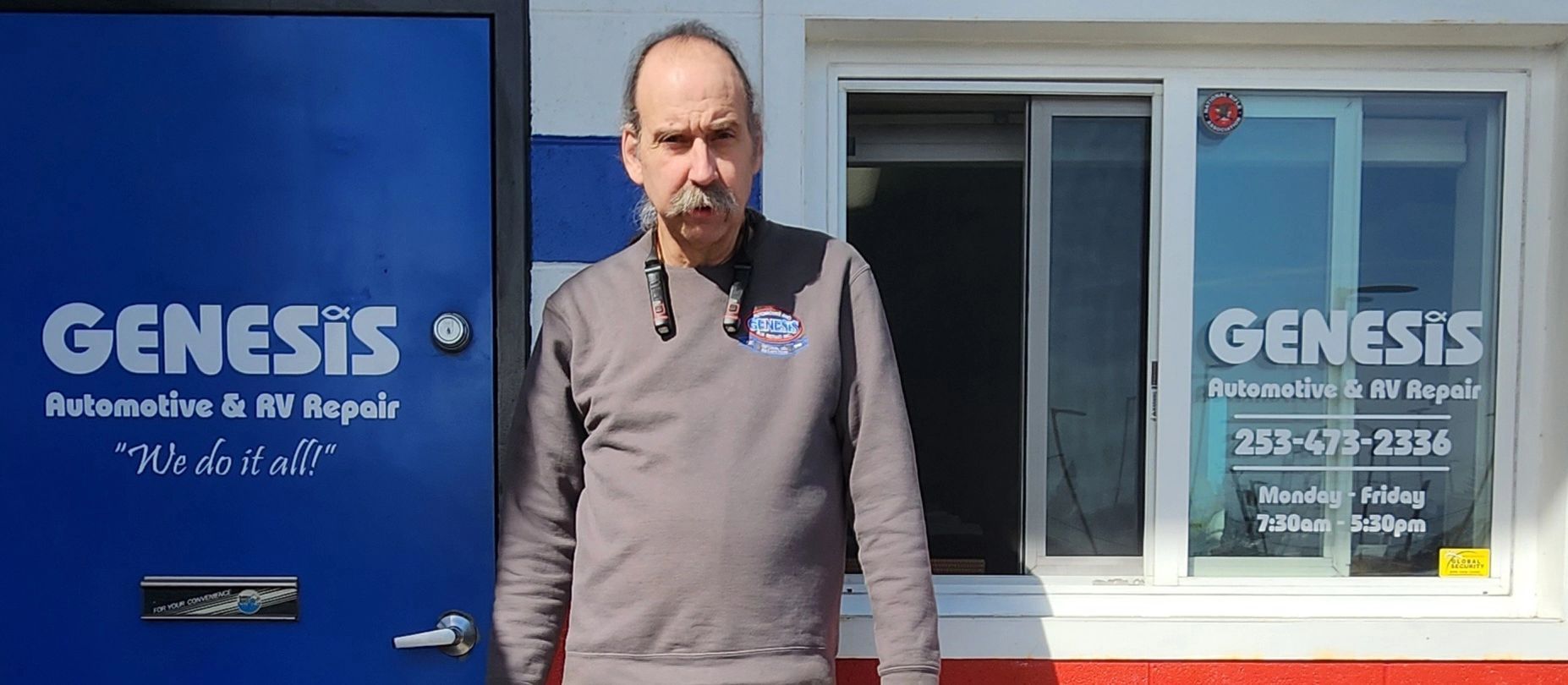 A man standing in front of his shop. The shop's name is "Genesis" | Genesis Automotive and RV Repair