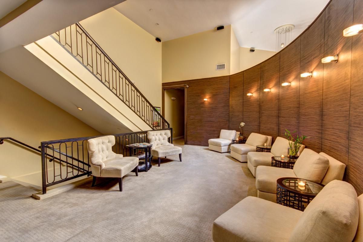 A waiting room with chairs and a staircase in the background