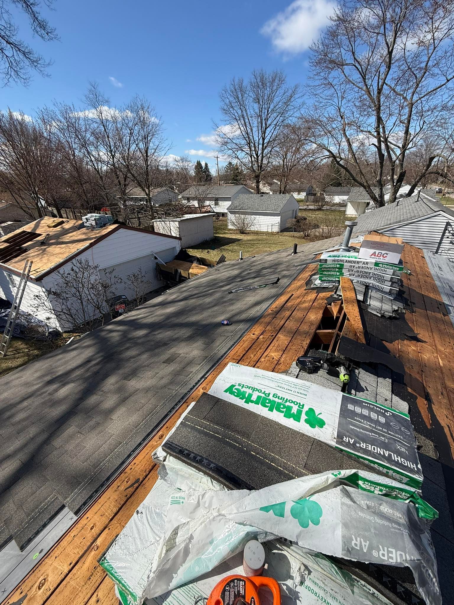 A roof is being repaired in a residential area.