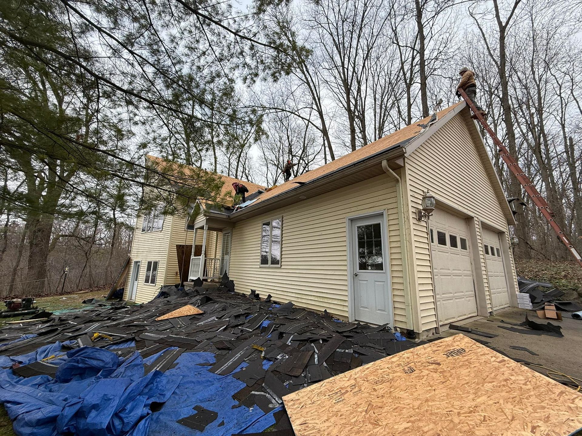 A house with a lot of shingles on the roof is being remodeled.
