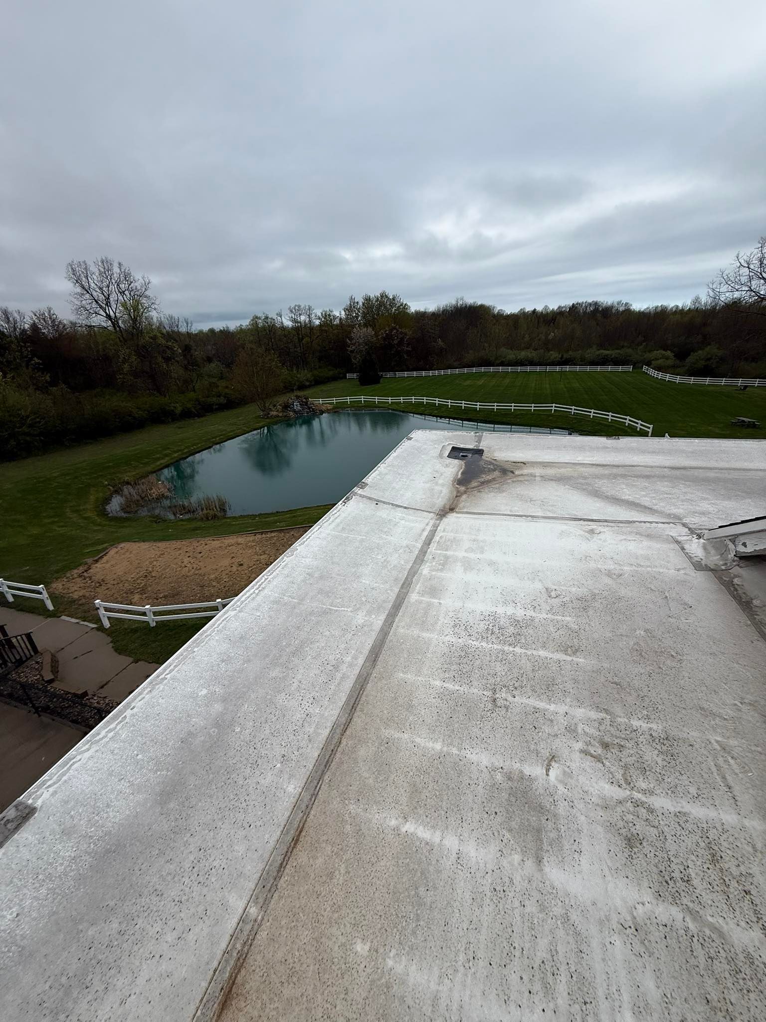 A white roof with a pond in the background on a cloudy day.