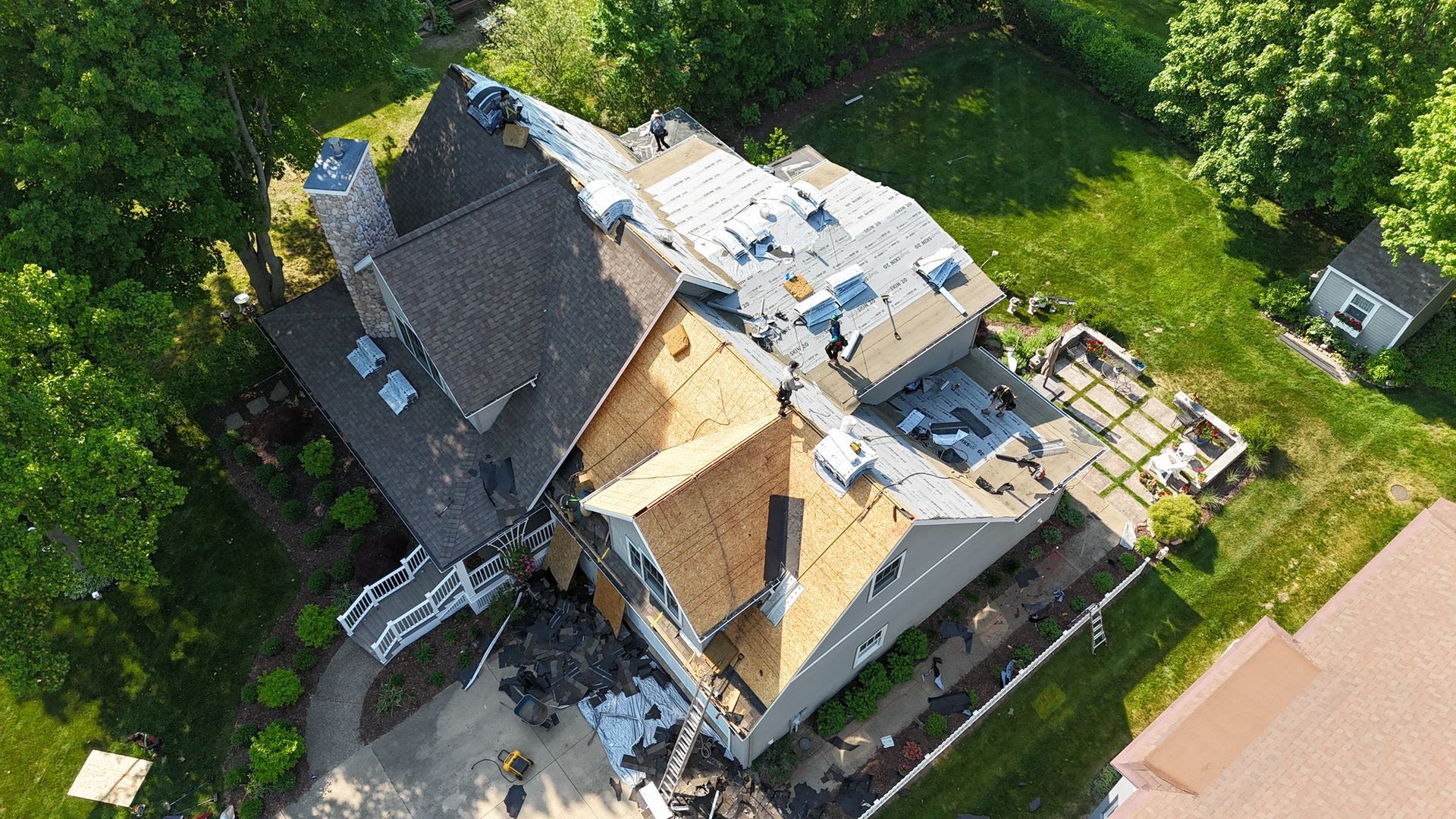 An aerial view of a house under construction with a roof being installed.