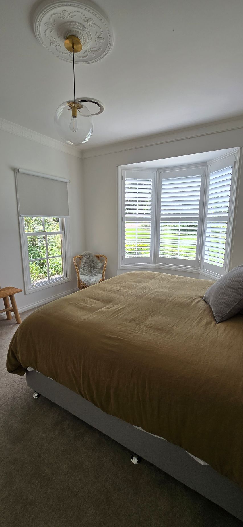 Bedroom with large bed, bay windows, and pendant light fixture. — Glenn Koek - Shutters - Curtains - Blinds in West Wollongong, NSW