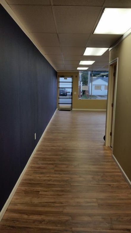 An empty hallway with hardwood floors and blue walls.