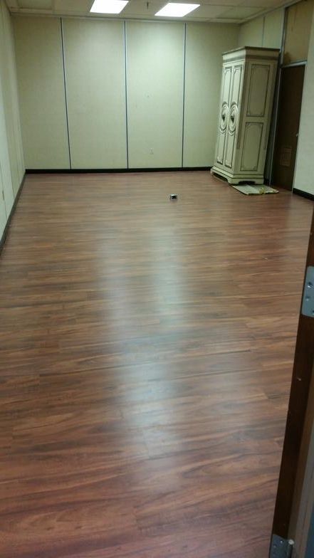 An empty room with a wooden floor and a dresser.