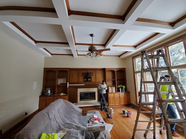 A living room with a couch and a fireplace being painted.