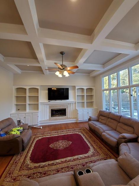 A living room with a fireplace , couch , chairs and a television.