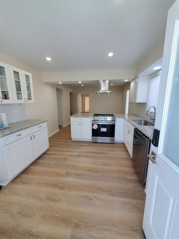 A kitchen with a stove , sink , and dishwasher.