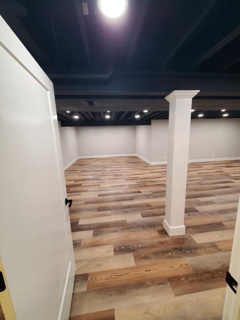 An empty basement with wooden floors and columns