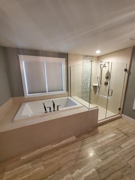 A bathroom with a jacuzzi tub and a walk in shower.