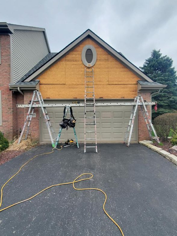 A ladder is sitting in front of a garage door.
