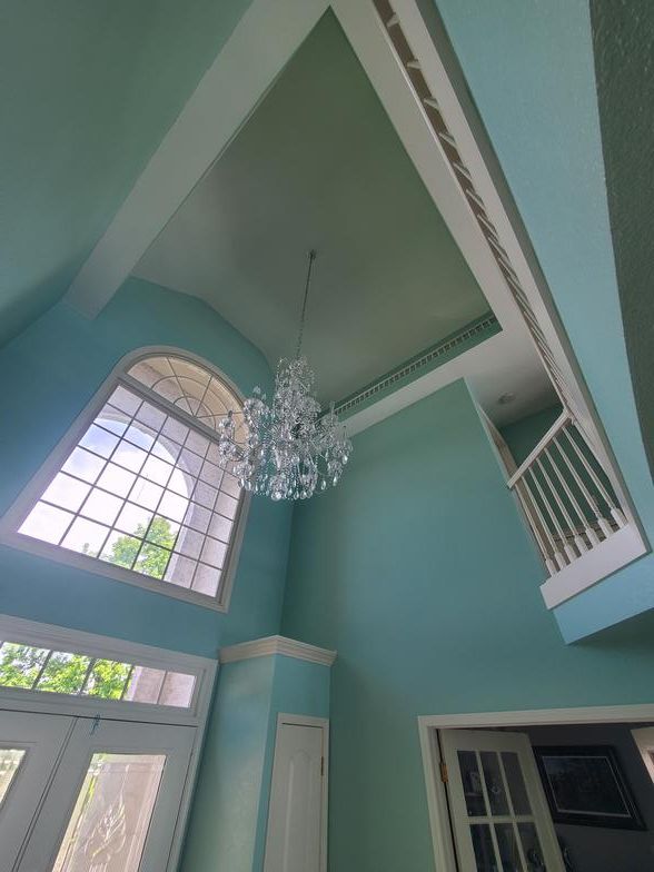 A room with blue walls and a chandelier hanging from the ceiling.