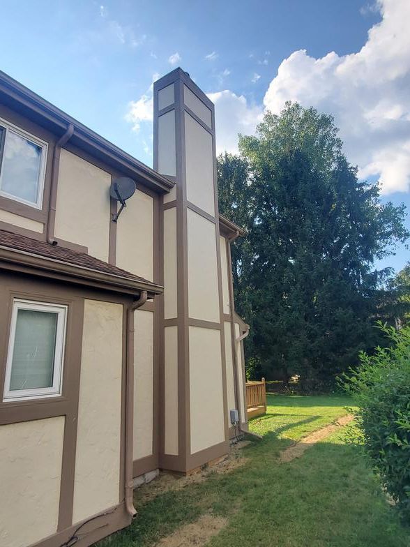 A house with a large chimney on the side of it.