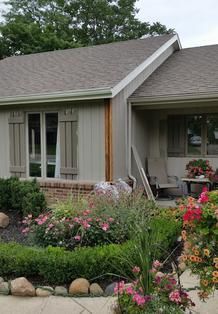 A small house with a lush green garden in front of it.