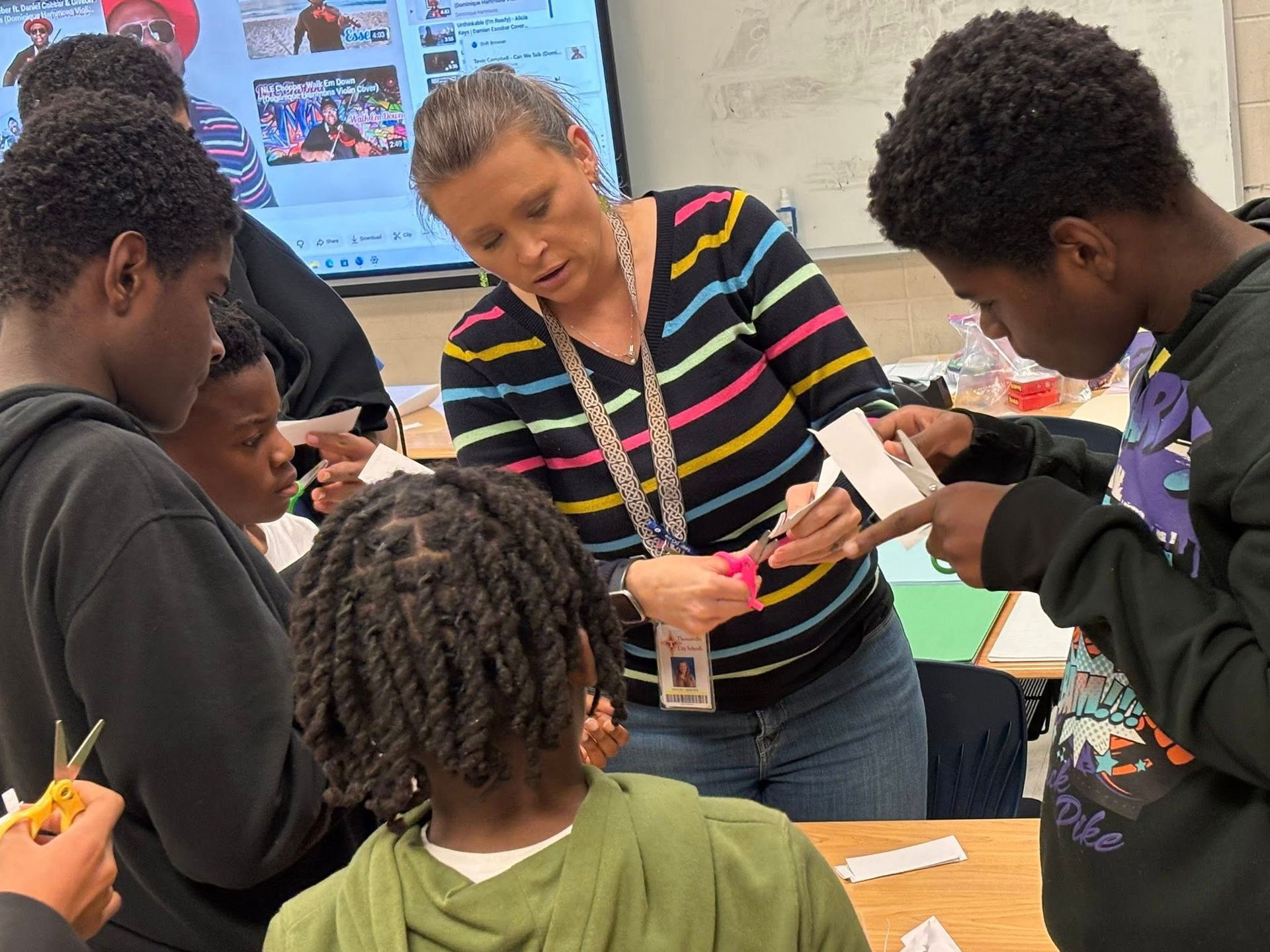 Girl pushing a black fitness sled with red weights outdoors.