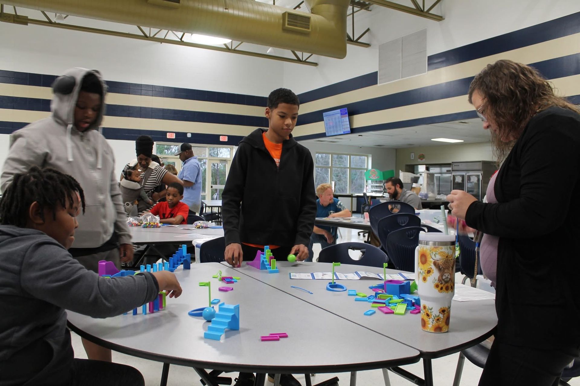 Girl pushing a black fitness sled with red weights outdoors.