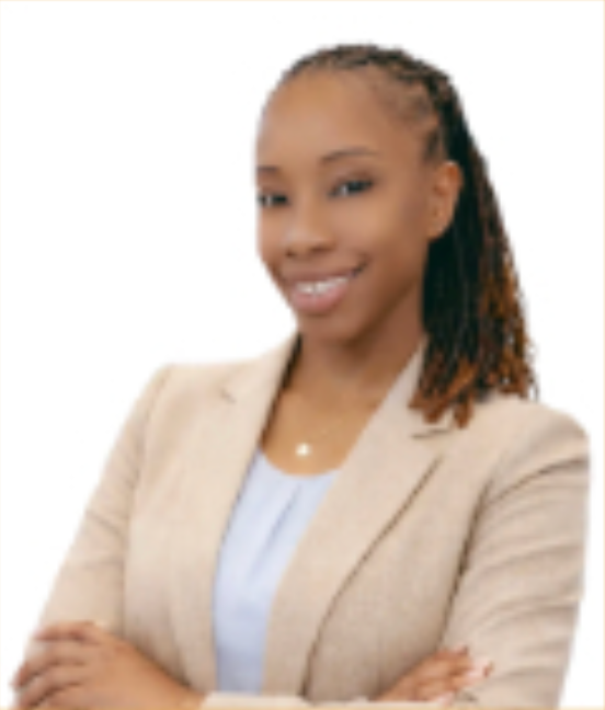 Man in a blue shirt standing outdoors, smiling. Background features greenery, fence.