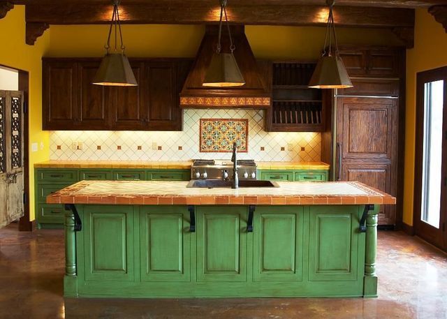 Modern kitchen with green island, dark wood cabinets, and hanging pendant lights