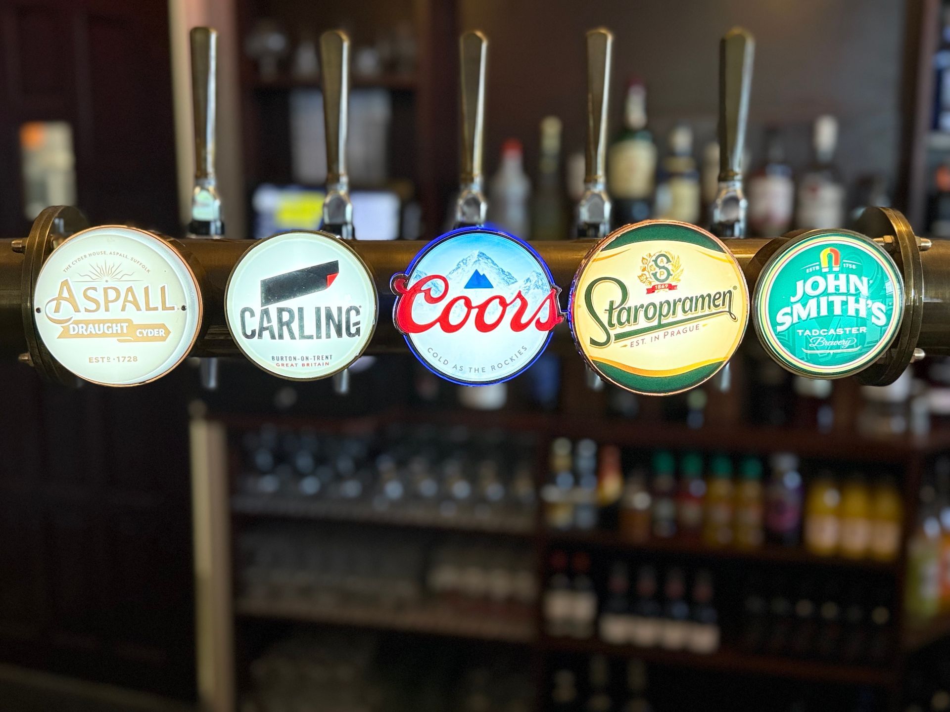Beer taps with illuminated logos: Aspall, Carling, Coors, Strongbow, and John Smith's.