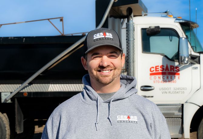 tyler link standing in front of a dump truck that says cesars concrete