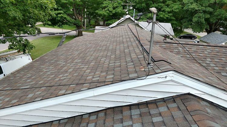The roof of a house with a satellite dish on it.