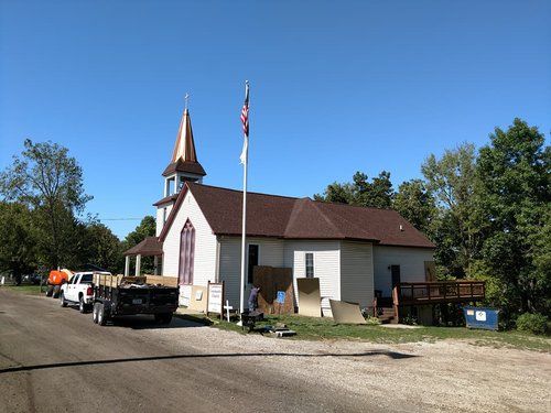 A small church with a flag on a pole in front of it