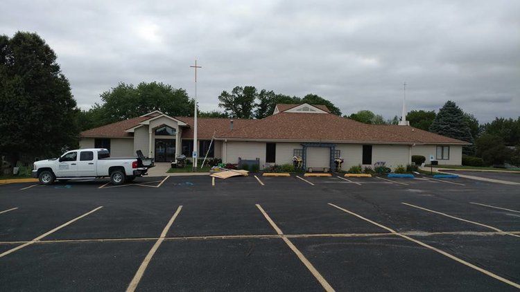 A white truck is parked in front of a building