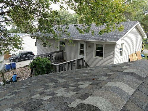 A house with a roof that is being installed on top of it.
