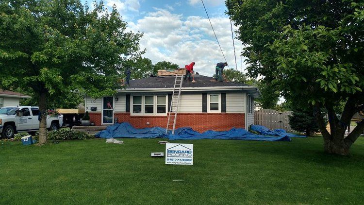 A couple of men are working on the roof of a house.