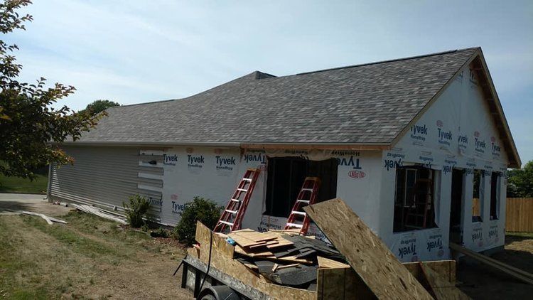 A house is being built with a ladder on a trailer.