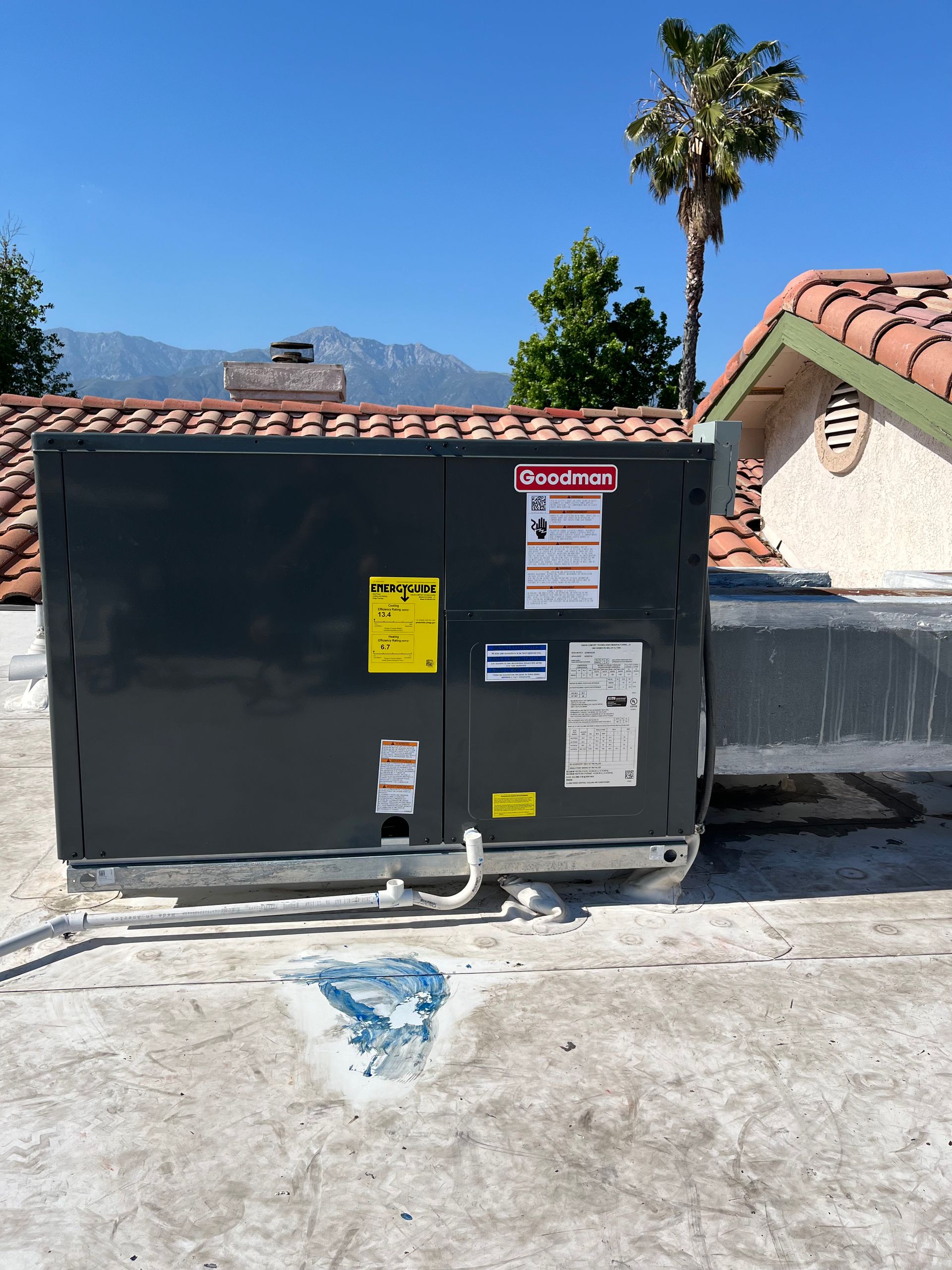Two HVAC units, one new and enclosed, one old and open, outside a door.