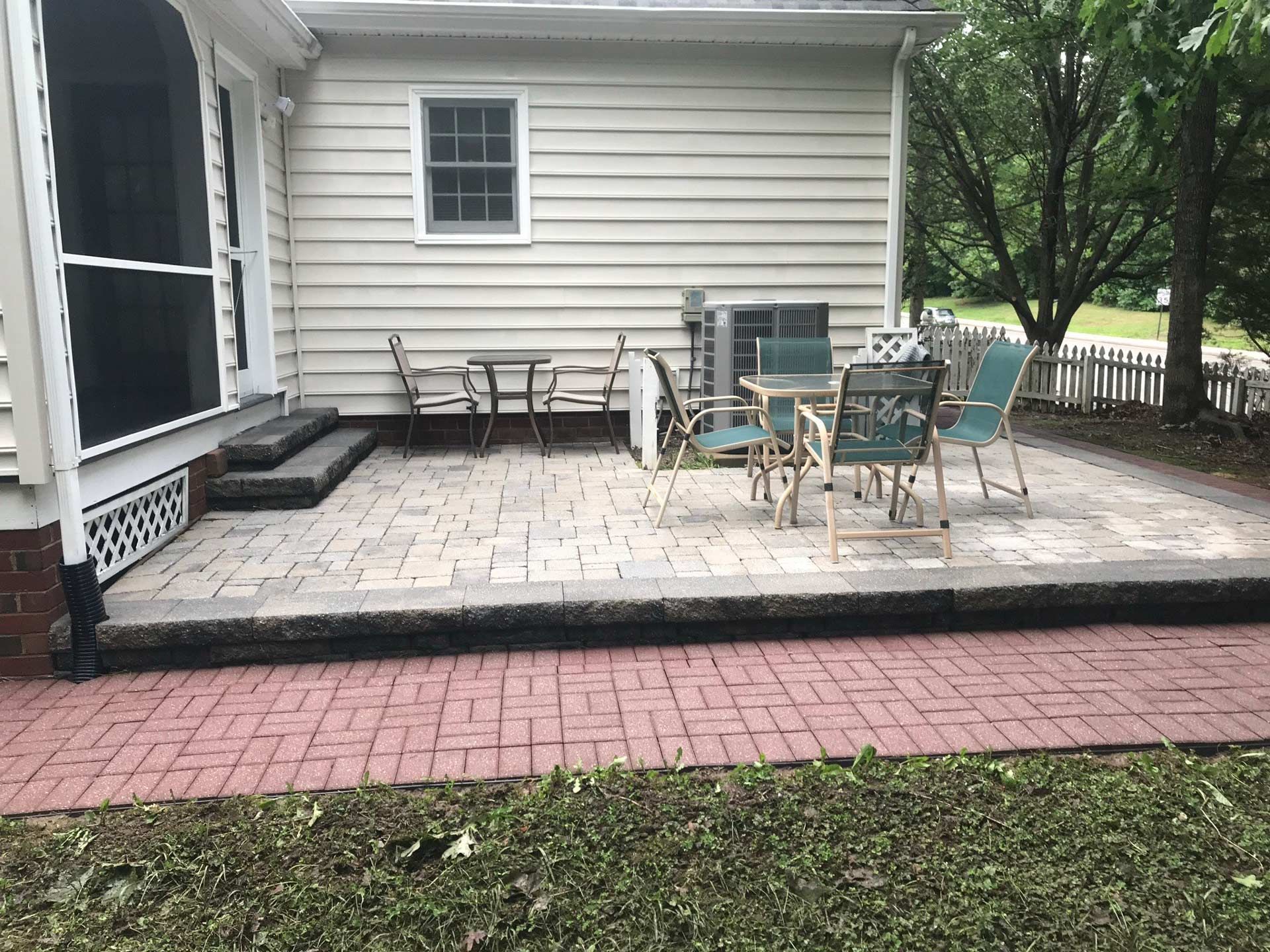 A patio with a table and chairs in front of a house