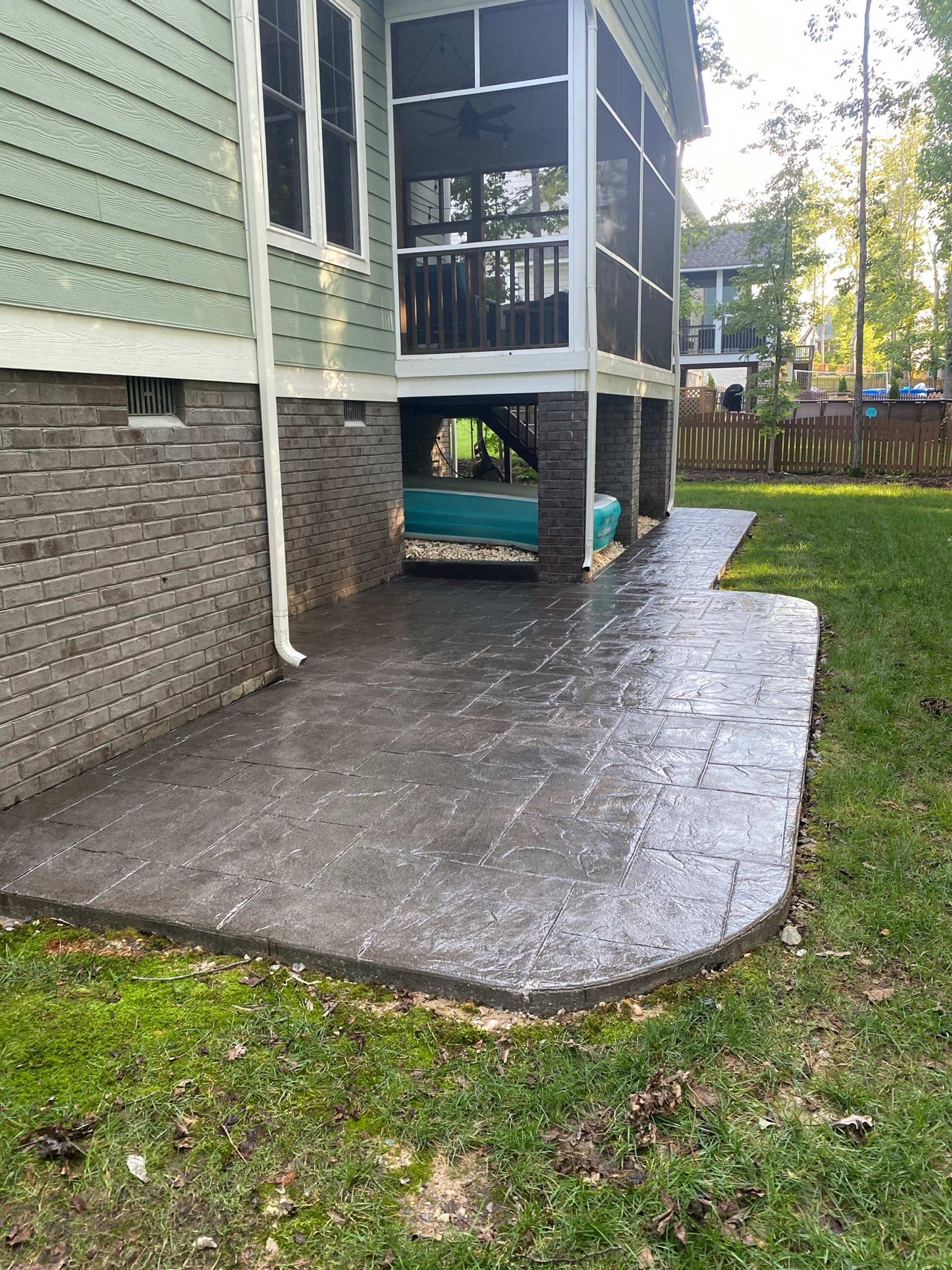 A patio with a screened in porch next to a house