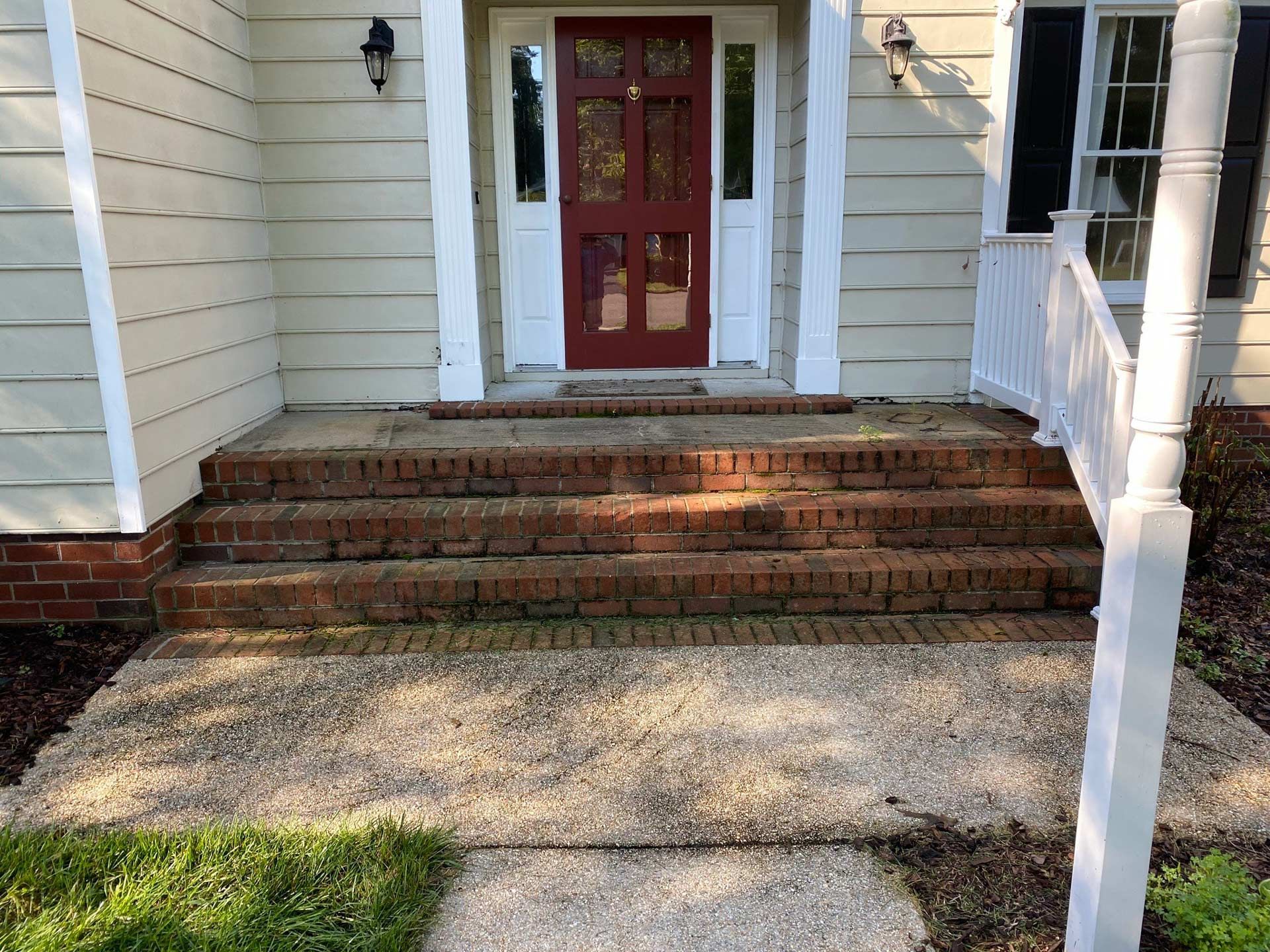 The front of a house with brick steps and a red door
