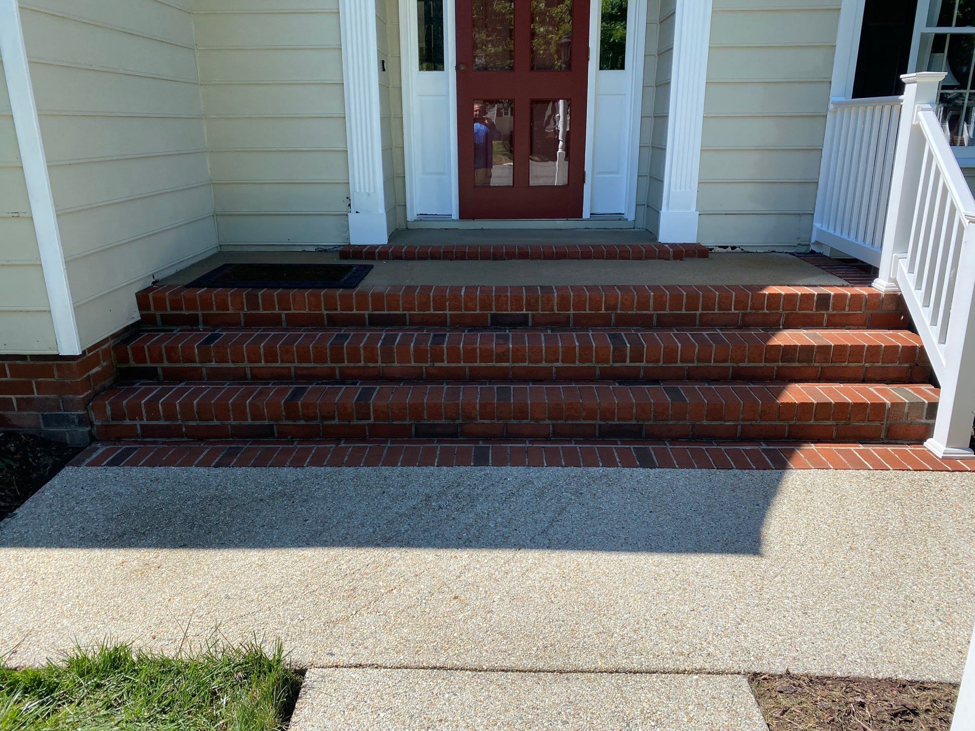A brick walkway leading to the front door of a house