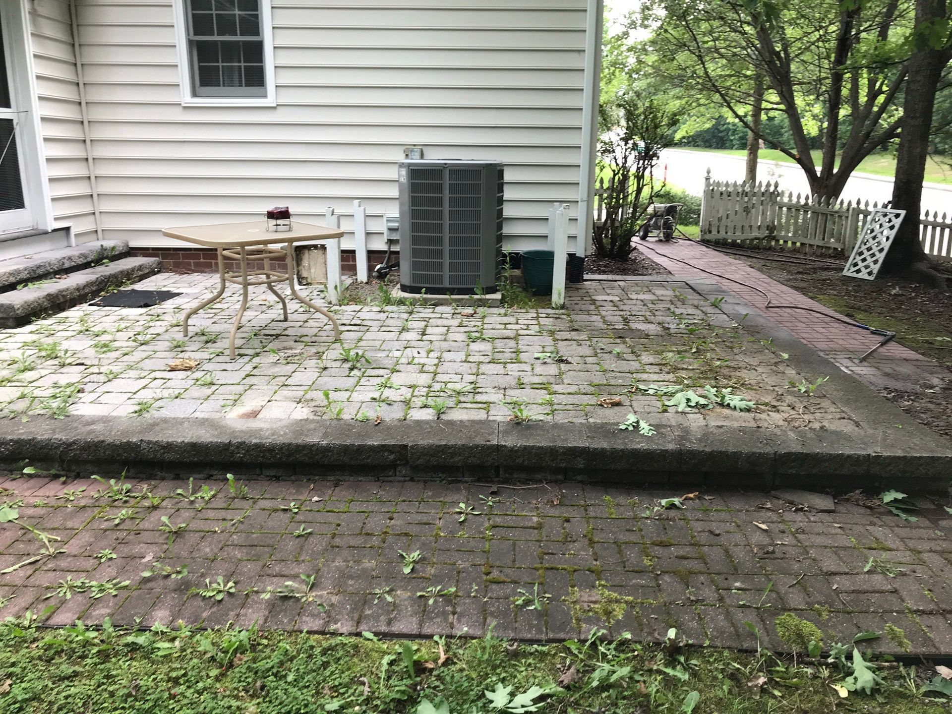 A patio with a table and chairs in front of a house.