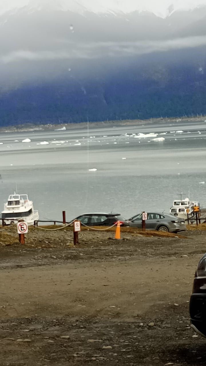 Un barco está atracado en un estacionamiento al lado de un cuerpo de agua.