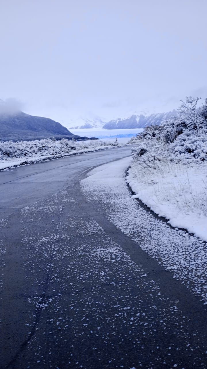 Una carretera nevada con un lago al fondo